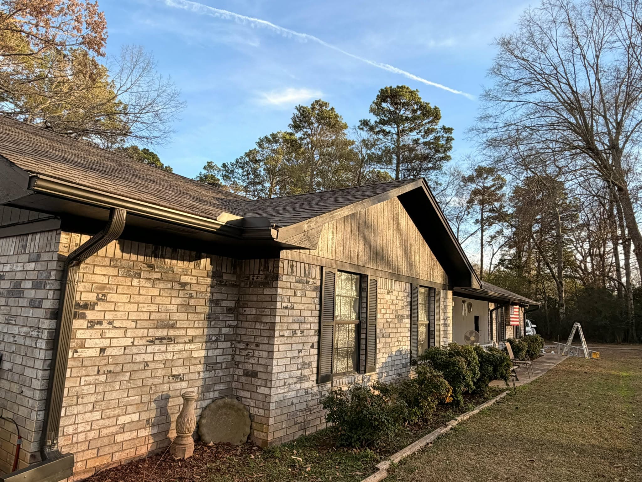 Before — brick house with old weathered wood siding